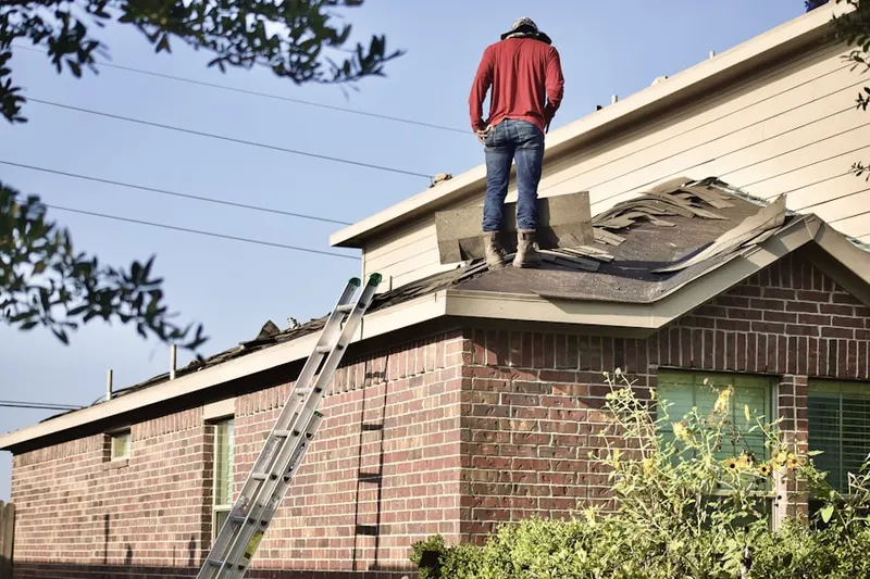Professional roofer working on a residential roof in Rieth